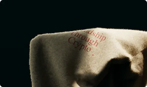Close-up van de gebreide stof met 'Friendship Through Crypto' in rode letters